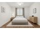 Bright bedroom featuring a large window, neutral decor, and wood-look floors with a white rug at 18325 W Port Au Prince Ln, Surprise, AZ 85388