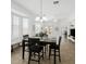 Bright dining room with a sleek black table set and large windows overlooking the backyard at 18325 W Port Au Prince Ln, Surprise, AZ 85388
