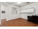 Spacious living room with hardwood floors, white cabinets, and arched doorway at 18325 W Port Au Prince Ln, Surprise, AZ 85388
