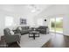Bright living room with neutral decor, vaulted ceilings, and sliding glass door to outdoor space at 18325 W Port Au Prince Ln, Surprise, AZ 85388