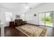 Cozy living room featuring wood floors, a neutral rug, and a slider to the outdoor patio at 18325 W Port Au Prince Ln, Surprise, AZ 85388