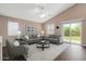 Modern living room featuring a vaulted ceiling, stylish seating, and a sliding glass door to the outdoors at 18325 W Port Au Prince Ln, Surprise, AZ 85388