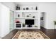 Stylish living room featuring built-in shelving, fireplace, and wood flooring, creating a modern and inviting atmosphere at 18325 W Port Au Prince Ln, Surprise, AZ 85388