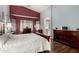 Serene primary bedroom suite with soft lighting, vaulted ceilings, and elegant wood furniture at 18325 W Port Au Prince Ln, Surprise, AZ 85388