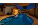 Inviting pool and covered patio area perfect for relaxing and entertaining outdoors at twilight at 18325 W Port Au Prince Ln, Surprise, AZ 85388