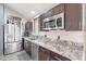 Modern kitchen with stainless steel appliances, granite countertops, and generous cabinet space at 19440 N 12Th St, Phoenix, AZ 85024