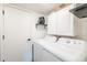 Functional laundry room with a washer, dryer, storage cabinets, and convenient shelving at 19440 N 12Th St, Phoenix, AZ 85024