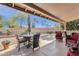 Covered patio with dining and sitting area overlooking the landscaped yard at 19791 N 86Th Dr, Peoria, AZ 85382