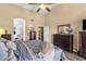 Spacious bedroom with wood-look floors, a ceiling fan, and connecting to a bright bathroom at 19791 N 86Th Dr, Peoria, AZ 85382