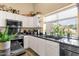 Bright kitchen with stainless steel appliances, white cabinets, and dark countertops at 19791 N 86Th Dr, Peoria, AZ 85382