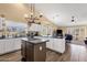 Open-concept kitchen with dark countertops and an island flowing into the living space at 19791 N 86Th Dr, Peoria, AZ 85382