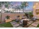 Inviting backyard with a cozy fire pit, stylish seating, manicured landscaping, and privacy wall at 21073 W Sunrise Ln, Buckeye, AZ 85396