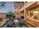 Backyard patio with fire pit and seating area at dusk, with view of upper balcony at 21073 W Sunrise Ln, Buckeye, AZ 85396