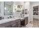 This bathroom has separate and sinks, tiled walls, floating shelves, and modern fixtures at 21073 W Sunrise Ln, Buckeye, AZ 85396
