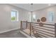 Hallway showcasing the railing design, wall decor, natural light, and the staircase leading to the lower floor at 21073 W Sunrise Ln, Buckeye, AZ 85396