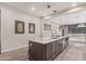 Contemporary kitchen island features stainless faucet, white countertops and a view into the living area at 21073 W Sunrise Ln, Buckeye, AZ 85396