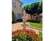 Backyard with a beautiful water fountain, red brick patio, manicured landscaping, and mature trees at 21538 N 59Th Ln, Glendale, AZ 85308