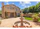 Expansive backyard with a water fountain, brick patio, lush green lawn, and a glimpse of the home's architecture at 21538 N 59Th Ln, Glendale, AZ 85308