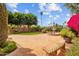 Charming backyard featuring brick patio, fountain, colorful flowers, bench seating, and well-maintained landscaping at 21538 N 59Th Ln, Glendale, AZ 85308