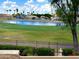 Scenic backyard view overlooking a lake, lush golf course, and well-maintained landscaping at 21538 N 59Th Ln, Glendale, AZ 85308