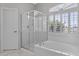 Well-lit bathroom featuring a glass shower, a large bathtub, and plantation shutters for privacy at 21538 N 59Th Ln, Glendale, AZ 85308