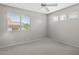 Bedroom featuring a ceiling fan and bright windows with views of the exterior at 21538 N 59Th Ln, Glendale, AZ 85308