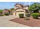 Exterior view of a two-story home with a tile roof, an attached two-car garage, and mature landscaping surrounding the property at 21538 N 59Th Ln, Glendale, AZ 85308