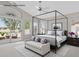 Staged main bedroom featuring a four poster bed, vaulted ceilings, and private balcony access at 21538 N 59Th Ln, Glendale, AZ 85308