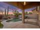 Backyard view of a pool and patio area with desert landscaping, block wall, and outdoor lighting at 22036 N 44Th Pl, Phoenix, AZ 85050