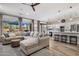 Open-concept living room and kitchen with hardwood floors, comfortable seating, and a breakfast bar at 22036 N 44Th Pl, Phoenix, AZ 85050