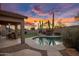 Backyard pool and patio area featuring desert landscaping at sunset at 22036 N 44Th Pl, Phoenix, AZ 85050