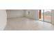 Bright, open-concept living room with sliding glass door, neutral carpeting and an ample amount of natural light at 25147 W Atlanta Ave, Buckeye, AZ 85326