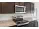 Close-up of a kitchen featuring modern stainless steel appliances and granite countertops at 25224 W Chanute Pass, Buckeye, AZ 85326