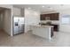 A modern kitchen featuring stainless steel appliances, granite countertops, and a center island at 25224 W Chanute Pass, Buckeye, AZ 85326