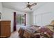 Cozy bedroom with a ceiling fan, patterned bedding, and a window with view of the beautiful outdoors at 2736 Leisure World --, Mesa, AZ 85206
