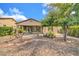 Well-maintained backyard with desert landscaping, mature trees, and a covered patio at 27614 N 129Th Ln, Peoria, AZ 85383