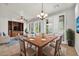 Open dining room with seating for six, wood floors, a chandelier and windows with white shutters at 27614 N 129Th Ln, Peoria, AZ 85383