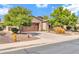 Inviting exterior showcasing a well-manicured lawn, mature trees, and a two-car garage at 27614 N 129Th Ln, Peoria, AZ 85383