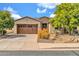 Charming home featuring a stone facade, a two car garage, desert landscaping and a paver driveway at 27614 N 129Th Ln, Peoria, AZ 85383