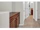 Hallway with wooden cabinets, tile floors, and access to the bathroom at 27614 N 129Th Ln, Peoria, AZ 85383