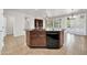 Open kitchen island with a black dishwasher, granite countertops and a view of the living area at 27614 N 129Th Ln, Peoria, AZ 85383