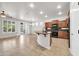 Open concept kitchen and living area with an island, granite countertops, wood cabinets, and stainless appliances at 27614 N 129Th Ln, Peoria, AZ 85383