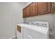 Practical laundry room with white washer and dryer units, storage cabinets, and functional layout at 27614 N 129Th Ln, Peoria, AZ 85383