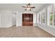 Bright living room with white walls, tile flooring, and custom built-in shelving at 27614 N 129Th Ln, Peoria, AZ 85383