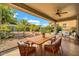 Charming covered patio with dining and lounge area overlooking the landscaped backyard at 27614 N 129Th Ln, Peoria, AZ 85383