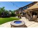 Inviting backyard with a blue glass fire pit, seating area, and lush greenery at 29431 N 23Rd Dr Dr, Phoenix, AZ 85085