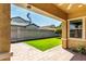View of green backyard from covered patio with exterior ceiling fan and brick pavers at 3023 E Arabian Dr, Gilbert, AZ 85296