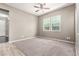Clean bedroom featuring neutral walls, carpeting, tile flooring, a ceiling fan, and a window for natural light at 3023 E Arabian Dr, Gilbert, AZ 85296