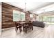 An open-concept dining room featuring a rustic accent wall and neutral-toned flooring at 3023 E Arabian Dr, Gilbert, AZ 85296
