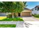Charming single-Gathering home with a well-kept lawn, mature tree, and brick driveway leading to a two-car garage at 3023 E Arabian Dr, Gilbert, AZ 85296
